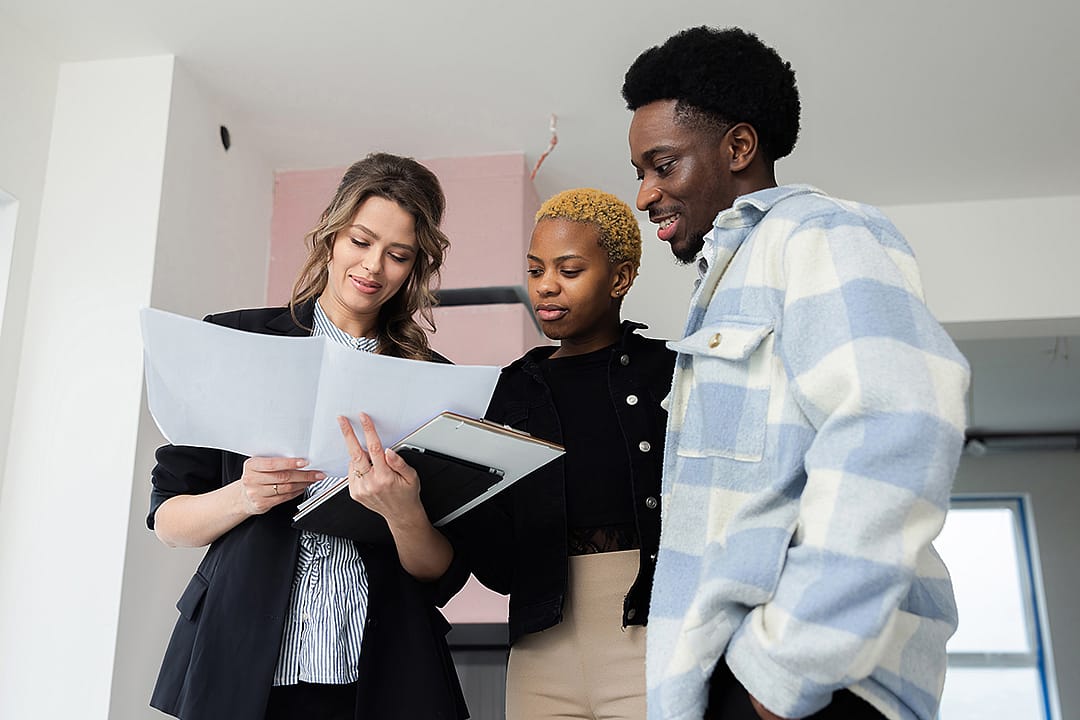 A young couple reviewing documents together with a property consultant.